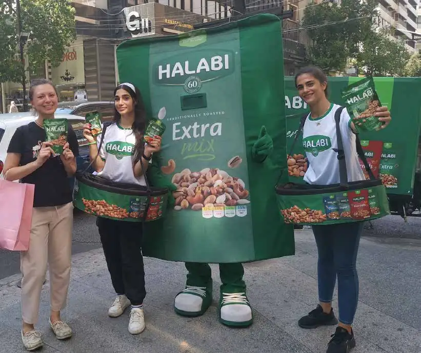 Halabi promoters and a giant nut-pack mascot sampling on the street