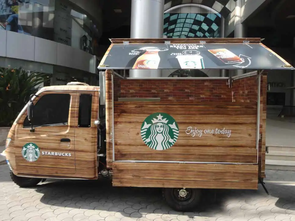 Starbucks-branded tuk-tuk coffee cart outside a shopping mall