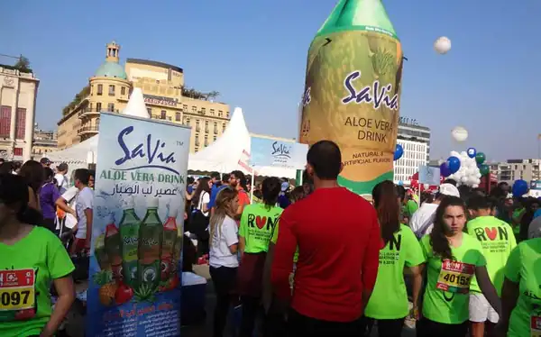 Giant Savia bottle and runners at a marathon village