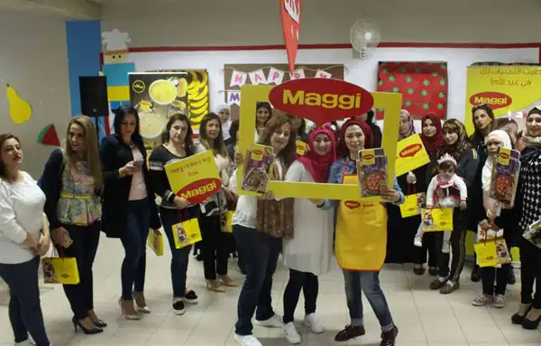 Women holding Maggi signs at an in-store Maggi cooking event